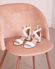 chaussures été en cuir blanc sur chaise en velours rose