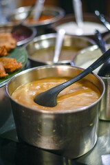 Bubur Candil, a traditional Indonesian sweet porridge made with glutinous rice flour and palm sugar syrup, served in a stainless steel pot. Popular dessert during Ramadhan and traditional festivities