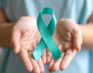close  up hands holding , showing , pinning a teal ribbons , supporting , demonstrating ovarian cancer awareness