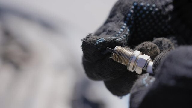 Caucasian man changing spark plugs in car. 