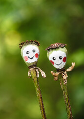 Happy little pair of smiling poppy seed heads with painted faces enjoys a sunny day in the summer cottage garden. Easy nature crafts and activities for Kids concept. Copy space
