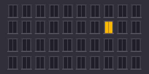 A tall, dark apartment complex with rows of identical windows. Only one yellow-lit window breaks the pattern, adding a hint of story and loneliness.