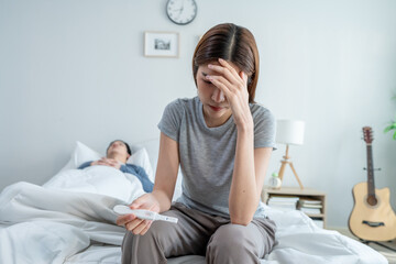 Asian young woman feel shock after look at positive pregnancy test. 