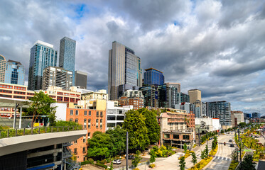 View of downtown Seattle, Washington, United States, captured from Overlook Walk. The elevated pedestrian pathway offers a sweeping panorama of the city's skyline, including modern skyscrapers and