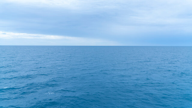 Vast blue ocean extending to the horizon under a cloudy sky