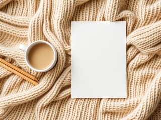 Fototapeta premium Blank card with warm beverage and pencils on a soft knitted blanket, perfect for message or design placement