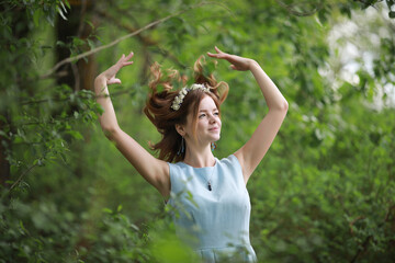 Girl in blue dress in green park