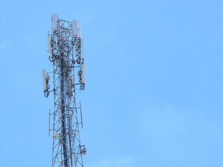 Tall telecommunications tower standing against a clear blue sky for cellular and radio signal transmission
