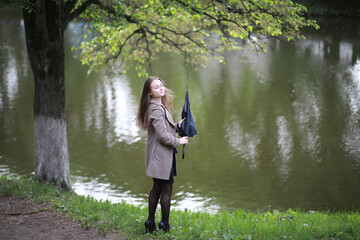 Young girl in a coat in a spring park