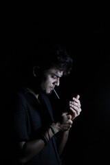 Obraz premium Mysterious Man Smoking in Dim Light – Stylish Dark Portrait on Black Background