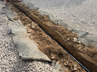 Trench Dug in Garden Soil for Underground Cable Installation.