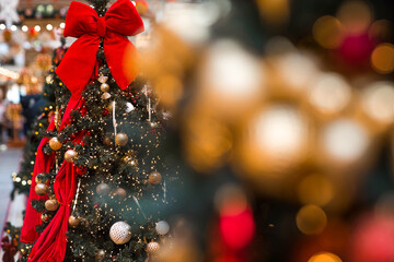 Holiday toys in red and gold colors on the New Year's tree. New Year's card 2026. Atmospheric...
