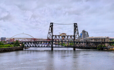 Double-deck vertical-lift Steel Bridge spans the Willamette River in Portland, Oregon, United States, and carries road, rail, pedestrian, and light rail traffic