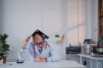 Frustrated doctor sits at a desk, using a folder as a makeshift hat. The office setting includes...