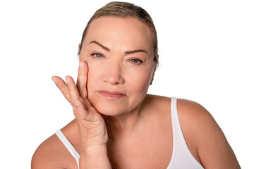 Mature woman applying skincare in bright setting, showcasing confidence and self-care routine while...
