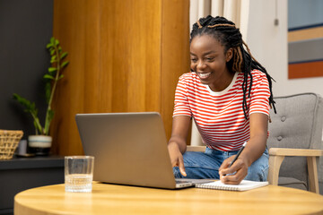 Young african american woman working online from home and looking involved