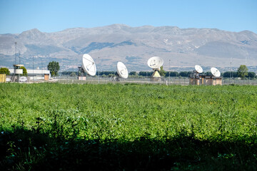 Panoramic view of large satellite dishes at the Fucino Space Centre, set against a backdrop of...