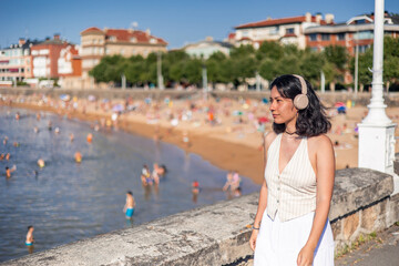copyspace Young asian woman wearing headphones enjoying summer near the beach in San Sebastian