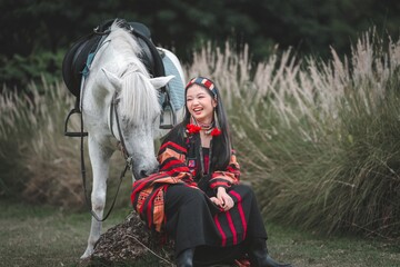 Young Woman in Traditional Clothing Smiling Beside White Horse