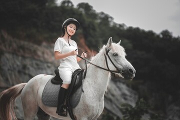 Young Rider Smiling on White Horse in Equestrian Setting