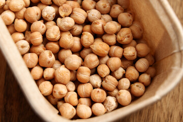 Dried chickpeas in cardboard packaging. Organic garbanzo ingredient. Top view. 