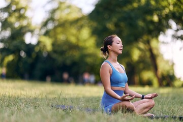 Young Woman Practicing Meditation Outdoors in a Peaceful Park Setting