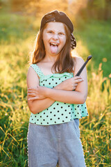 Portrait of smiling beautiful drummer girl crossed arms smiling at camera posing. Happy caucasian kid girl drummer. Girl playing on drum kit. Emotional portrait. Cheerful little girl playing drums