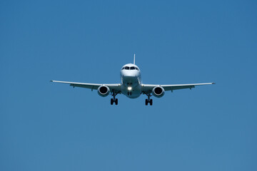 Plane ready to land against blue sky. Airplane flying in the blue sky, closeup of photo.