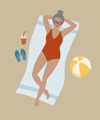 Gray haired woman lying on the beach in swimming suit, top view.