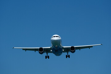 Plane ready to land against blue sky. Airplane flying in the blue sky, closeup of photo.