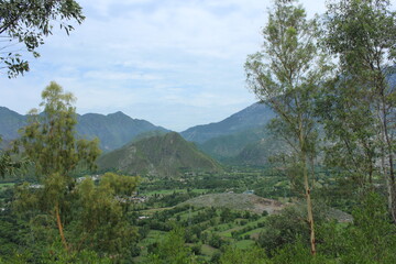 A breathtaking panoramic view of Swat, Pakistan, revealing lush green valleys, verdant fields, and...