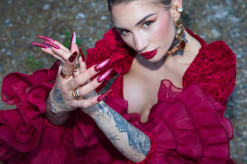 A beautiful woman dancing flamenco and clapping her hands at the fair in Seville, Spain. She is...