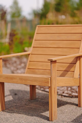 outdoor wooden chair in sunlight surrounded by garden greenery, ideal for backyard relaxation and...