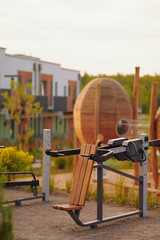 outdoor fitness park with modern exercise equipment amidst green residential setting. wooden...