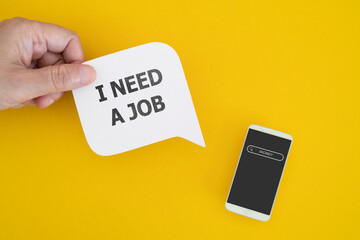hand hold real white speech bubble paper cut with I NEED A JOB  and white mobile phone with search...