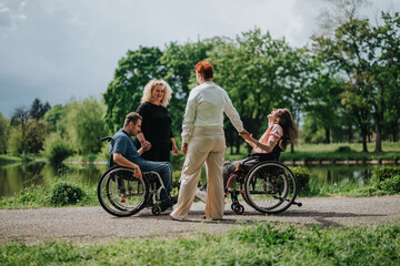 Obraz premium A diverse group of people, including two in wheelchairs, enjoying a lively gathering near a picturesque lake and fostering goodwill, laughter, and togetherness, surrounded by scenic natural beauty.