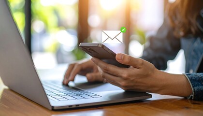Woman using laptop and smartphone, email notification