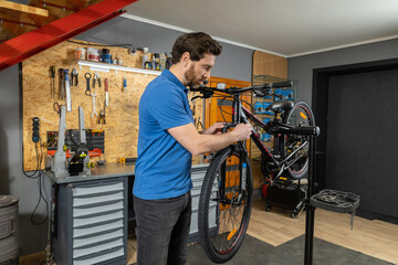 Bearded mechanic working on bike frame in workshop for cycle repair