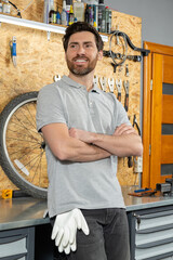 Mechanic standing with crossed arms in bicycle repair shop