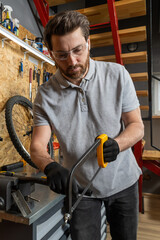 Bike mechanic in workwear using tools to repair bicycle