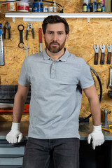 Mechanic man wearing white gloves standing in bicycle repair shop