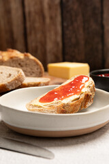 Slice of bread with butter and strawberry jam