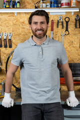 Mechanic man wearing white gloves standing in bicycle repair shop