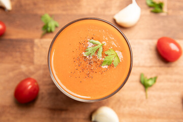 Top view of Gazpacho, Spanish cold tomato soup on wooden background.