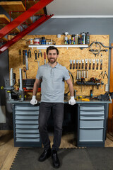 Bearded man standing indoor garage setting in white gloves