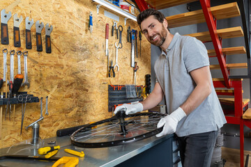 Mechanic man servicing bike using specialized tools in busy workshop
