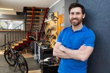 Man bike mechanic standing workshop entrance wearing blue t-shirt