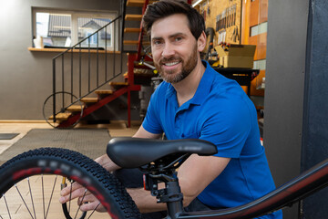 Man bike mechanic standing workshop entrance wearing blue t-shirt