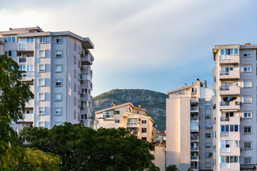 Modern apartment buildings in Bar, Montenegro with mountain backdrop and lush greenery