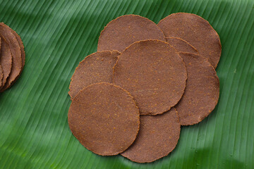 Fermented soybean discs, known as “Thua Nao,” a traditional Thai seasoning used to enhance...